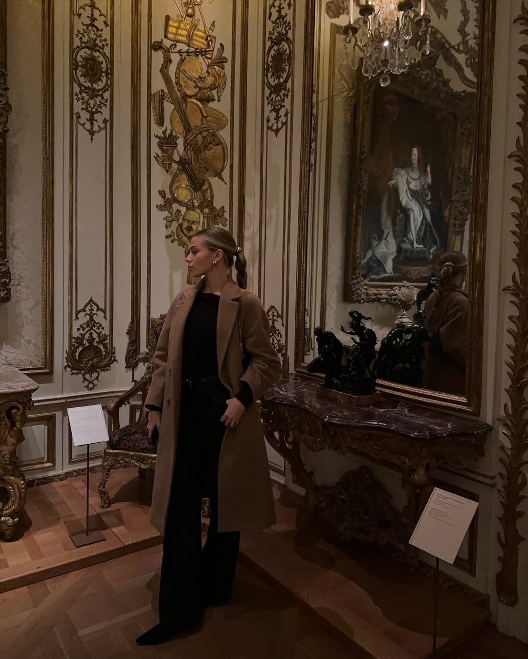 Nika surrounded by paintings in an ornate gallery
