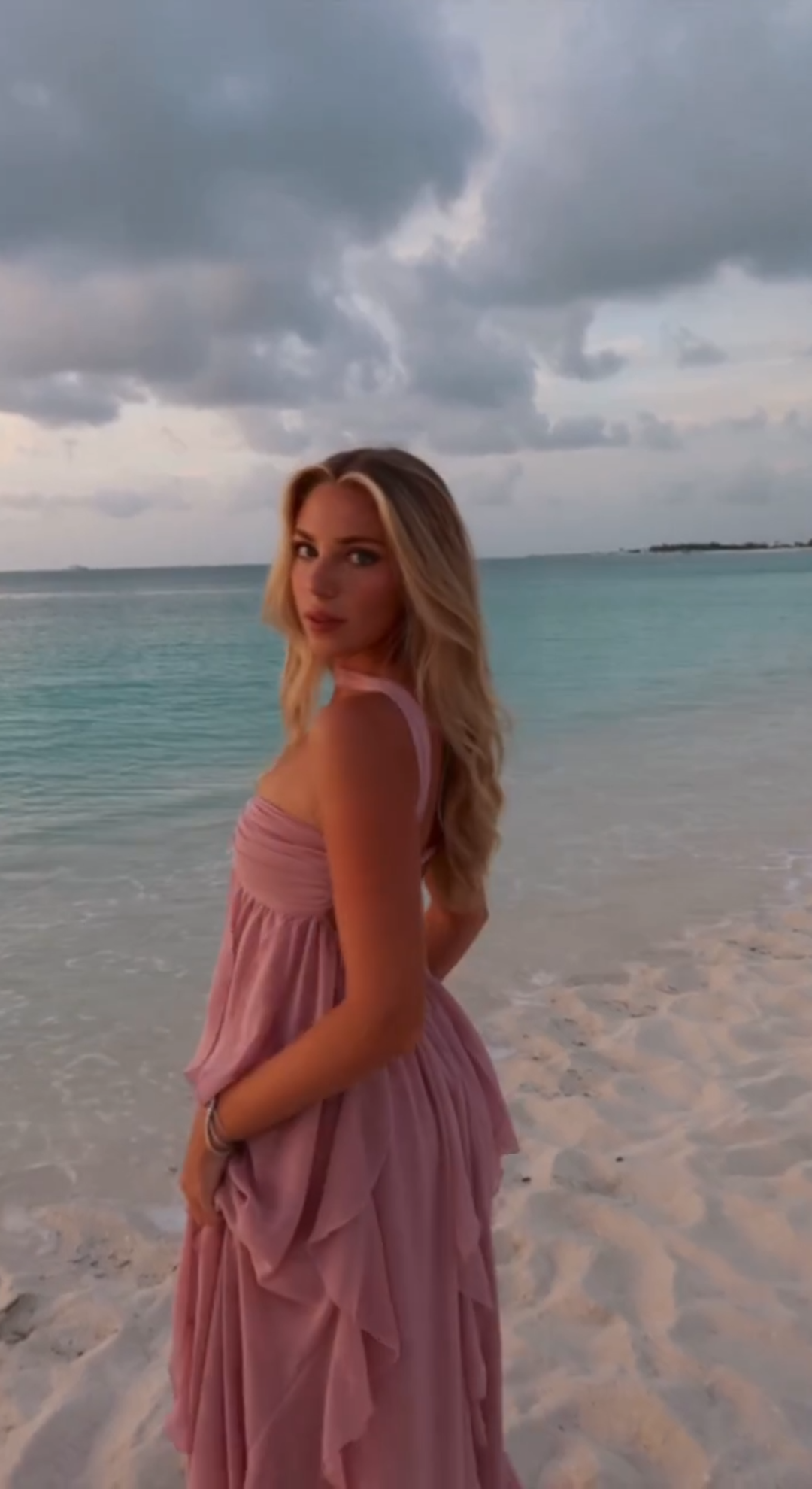 Nika wearing a pink dress by the sea